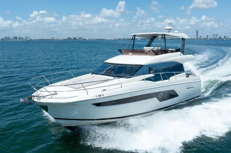 The Image of Luxury 2020 Prestige 520 yacht cruising on open water under a clear blue sky. - 0