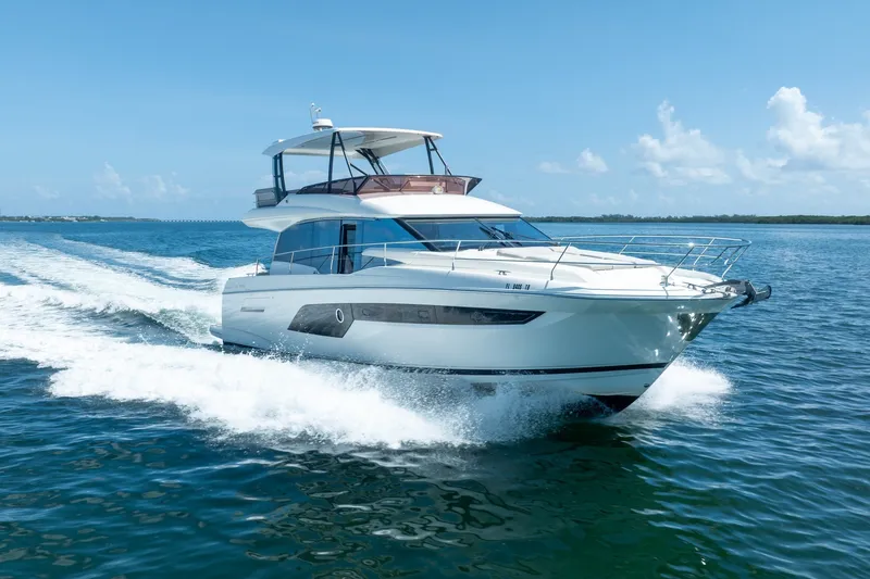Slide: The Image of 2020 Prestige 520 yacht cruising on open water under clear blue skies. - 9