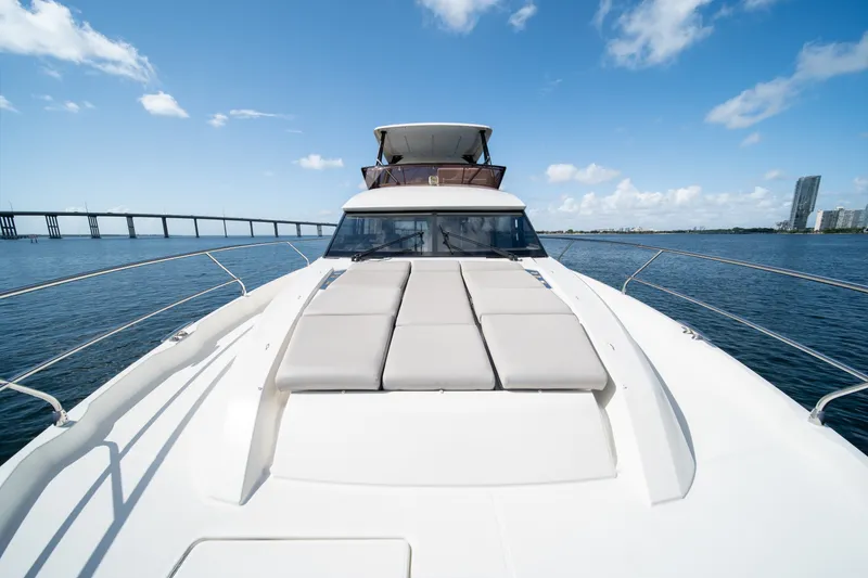 Slide: The Image of Luxury 2020 Prestige 520 yacht cruising under a clear blue sky near a bridge. - 36
