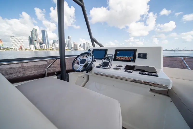 Slide: The Image of Helm of 2020 Prestige 520 yacht with city skyline in background. - 35