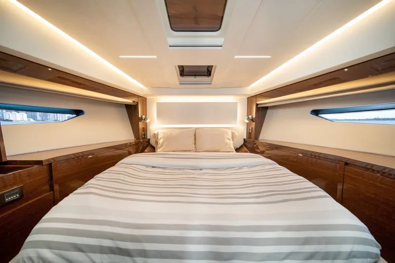 Slide: The Image of Luxurious bedroom interior of 2020 Prestige 520 yacht with modern lighting and elegant wood finishes. - 23