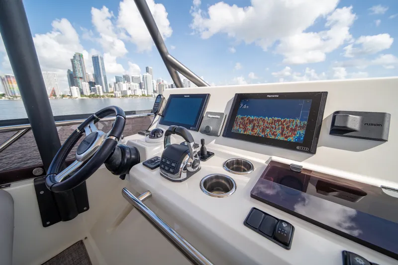 Slide: The Image of Cockpit of 2020 Prestige 520 yacht with city skyline in background. - 34