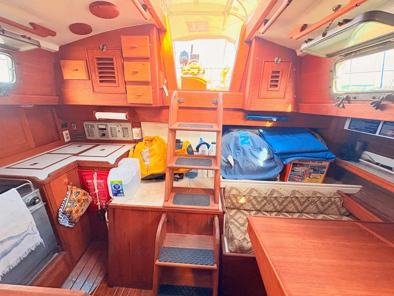 Slide: The Image of Interior of a 1979 Shannon 38 with wood paneling, stairs, and storage space. - 23