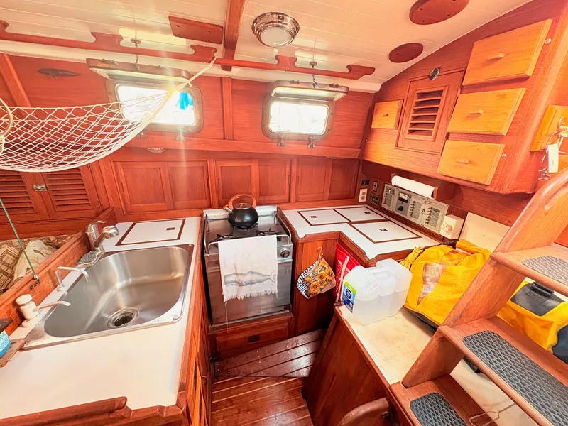 Slide: The Image of The galley of a 1979 Shannon 38 with wood paneling and a stainless steel sink. - 18