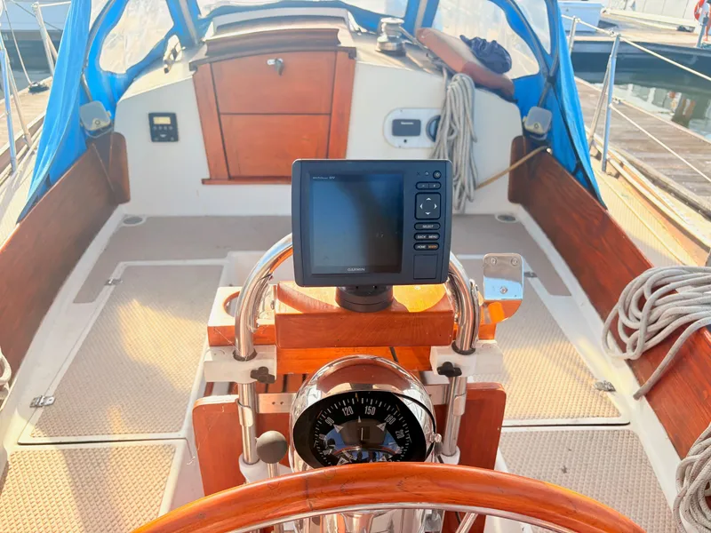 Slide: The Image of The cockpit of a 1979 Shannon 38 with a navigation system and wooden trim. - 16
