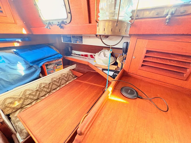 Slide: The Image of The interior of a 1979 Shannon 38 features a cozy cabin with wooden furnishings and a porthole. - 31