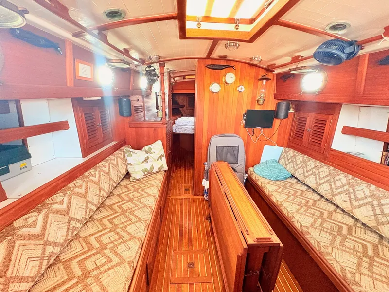 Slide: The Image of The interior of a 1979 Shannon 38 features a cozy cabin with wood paneling and seating. - 20