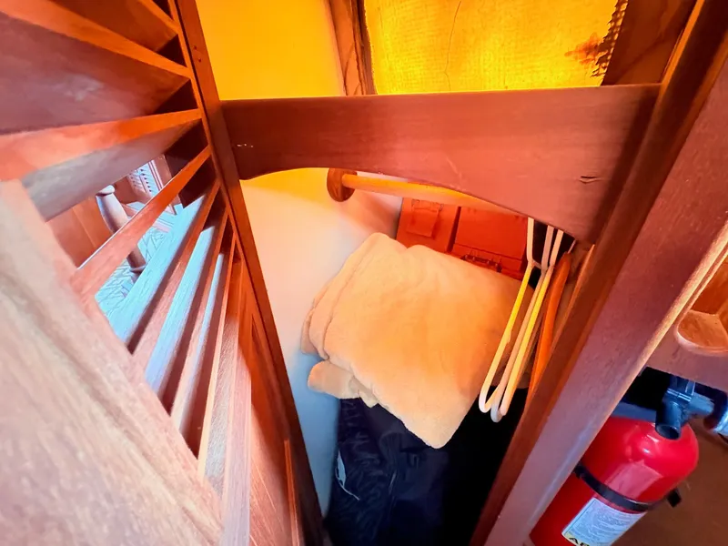 Slide: The Image of A closet with wooden doors, hangers, and a towel. A fire extinguisher is visible. - 27