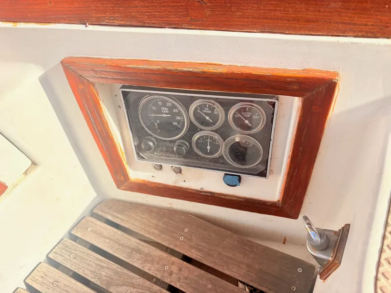 Slide: The Image of The image shows a wooden dashboard with several analog gauges and a wooden floor. - 15