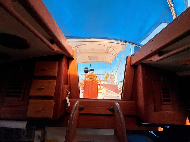 Slide: The Image of View from inside a 1979 Shannon 38, featuring wooden cabinetry and a blue canopy. - 32