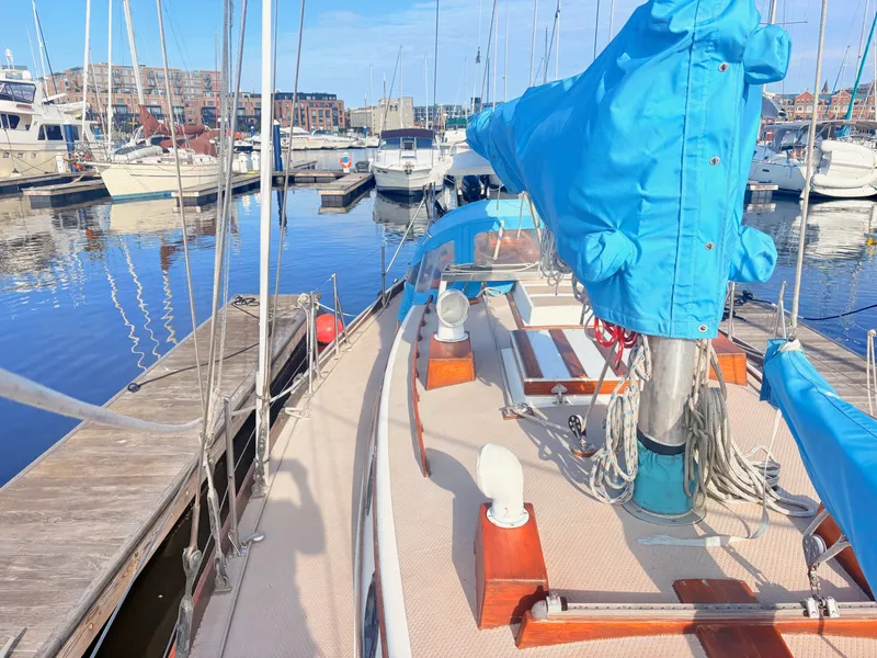 Slide: The Image of A 1979 Shannon 38 sailboat docked in a marina, featuring a blue sail cover. - 12