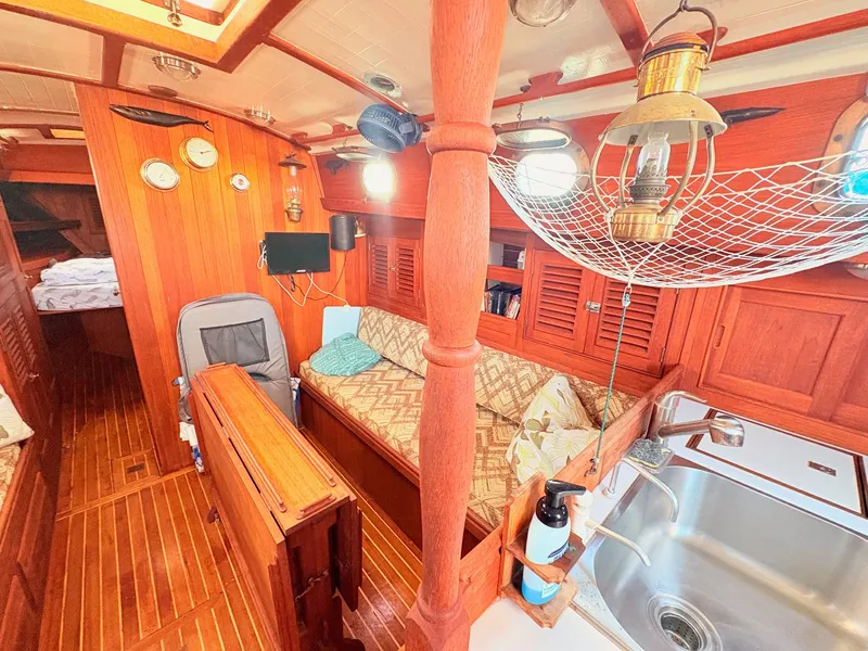 Slide: The Image of Interior of a 1979 Shannon 38 with wood finish, cozy seating area, and sink. - 19