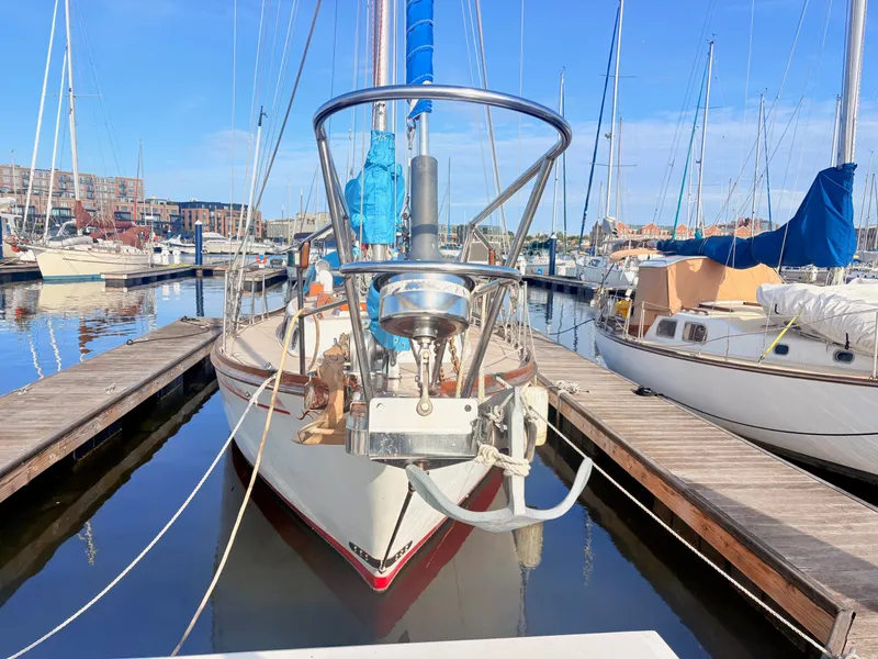 Slide: The Image of A 1979 Shannon 38 is docked in a calm marina, surrounded by other sailboats. - 1