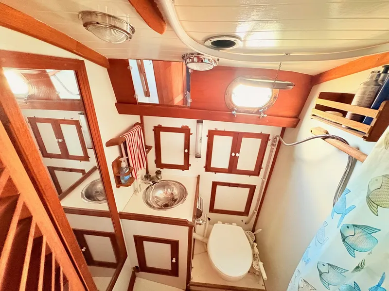 Slide: The Image of The image shows a boat bathroom with wood paneling, a sink, and a toilet. - 28
