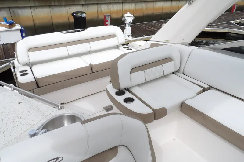 Slide: The Image of Luxurious seating area on a 2018 Regal 33 XO boat, featuring white and beige upholstery. - 19