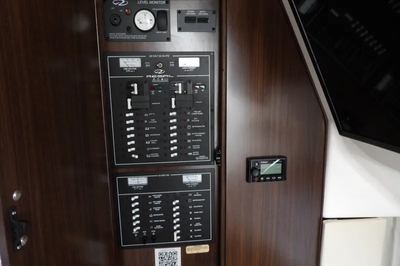 Slide: The Image of Control panel of a 2018 Regal 33 XO boat with various switches and gauges. - 35