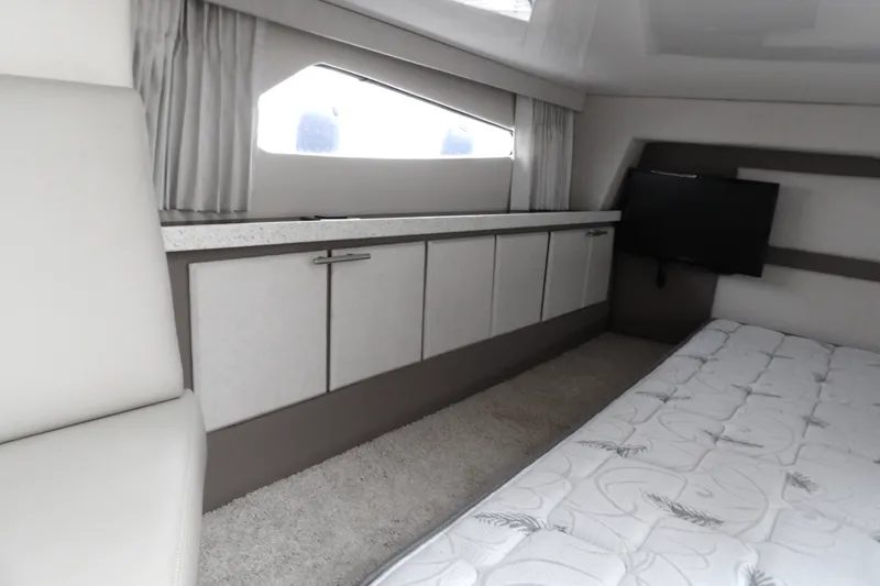 Slide: The Image of Interior of 2018 Regal 33 XO yacht with bed, cabinets, and TV. - 32