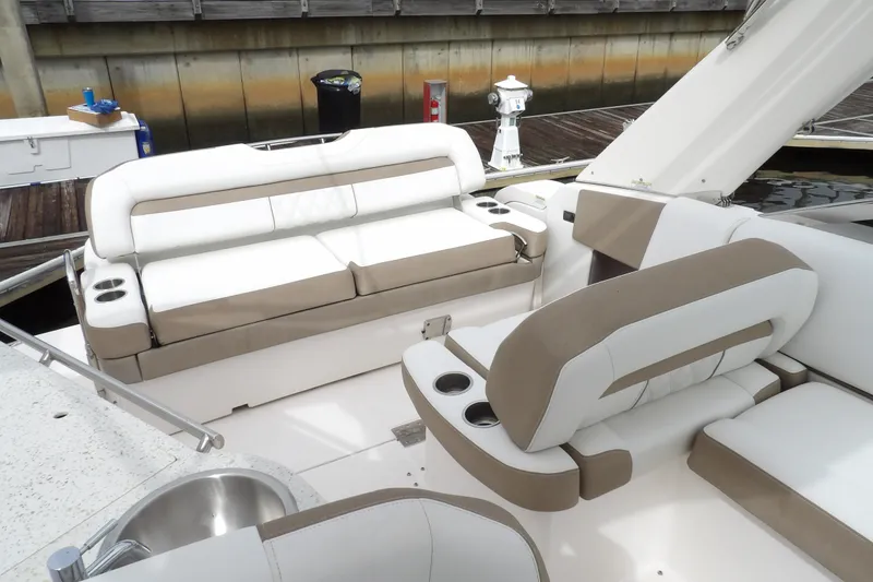 Slide: The Image of 2018 Regal 33 XO boat interior with beige and white seating, docked at marina. - 18
