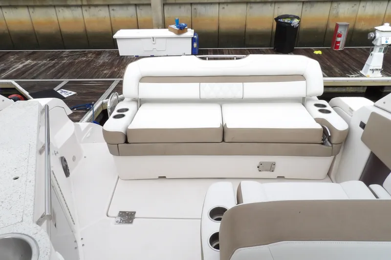 Slide: The Image of 2018 Regal 33 XO boat interior with white and beige seating, docked at a marina. - 13