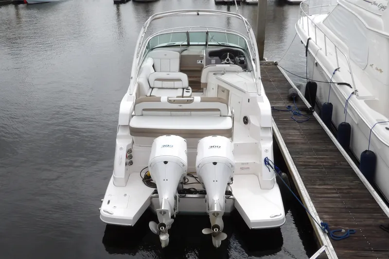 Slide: The Image of 2018 Regal 33 XO boat docked with dual outboard engines, featuring spacious seating. - 5
