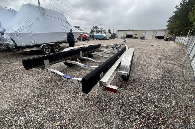 Slide: The Image of Trailer for 2018 Regal 33 XO boat in a gravel lot with covered boats. - 42