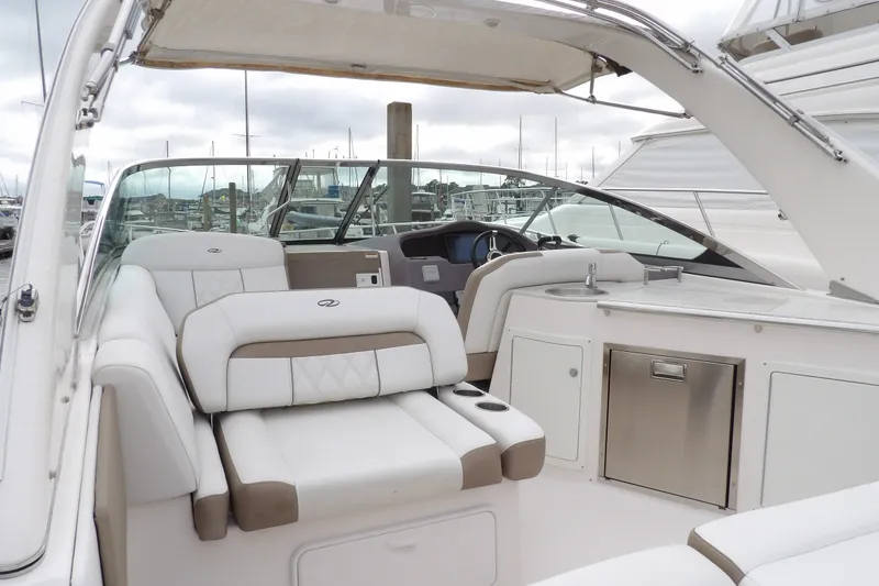 Slide: The Image of 2018 Regal 33 XO boat interior with white seating and helm, docked at marina. - 11