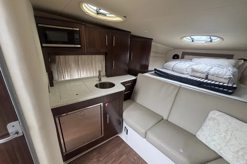 Slide: The Image of 2018 Regal 33 XO yacht interior with kitchenette, seating, and bedding area. - 27
