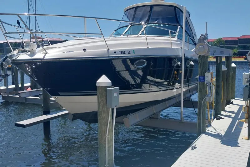 Slide: The Image of 2011 Monterey 340 Sport Yacht docked at marina, elevated on lift. - 2