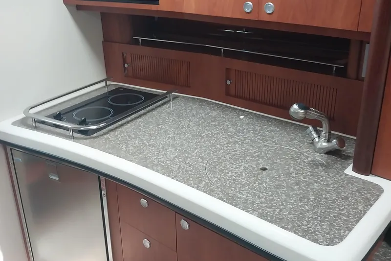 Slide: The Image of Compact kitchen area in a 2011 Monterey 340 Sport Yacht with stove and sink. - 12