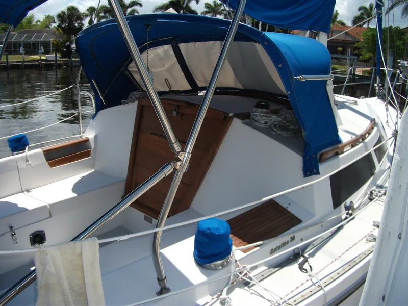 Slide: The Image of 1992 Catalina 30 MkII sailboat with blue canopy and wooden accents docked at marina. - 3