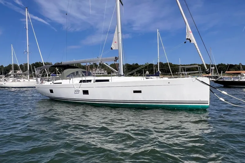 Slide: The Image of 2020 Hanse 458 sailboat on water, clear sky, marina background. - 1