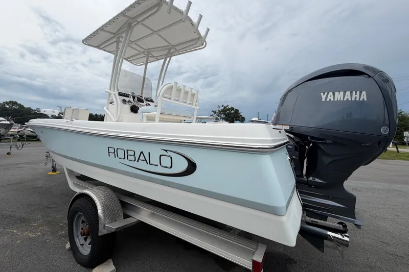 Slide: The Image of 2024 Robalo 206 Cayman boat with Yamaha engine on trailer, under cloudy sky. - 6