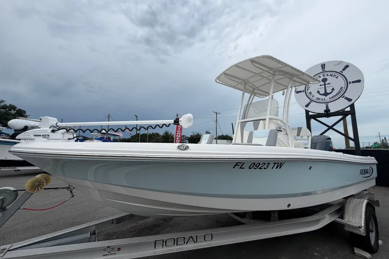 Slide: The Image of 2024 Robalo 206 Cayman boat on trailer, displayed outdoors under cloudy sky. - 8