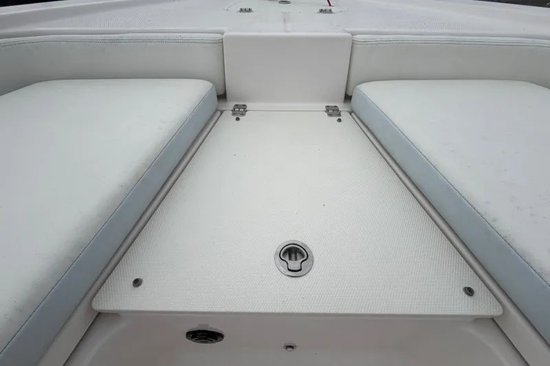 Slide: The Image of 2024 Robalo 206 Cayman boat interior with cushioned seating and storage compartment. - 28