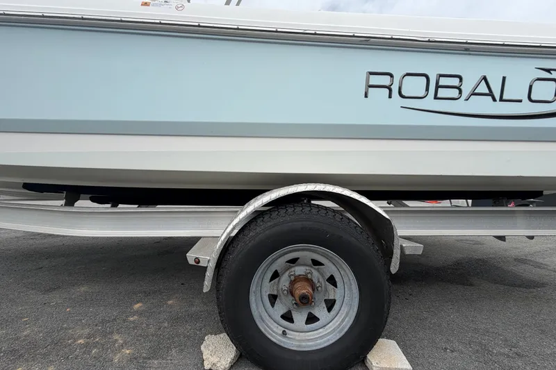 Slide: The Image of 2024 Robalo 206 Cayman boat on trailer, side view with visible wheel. - 67