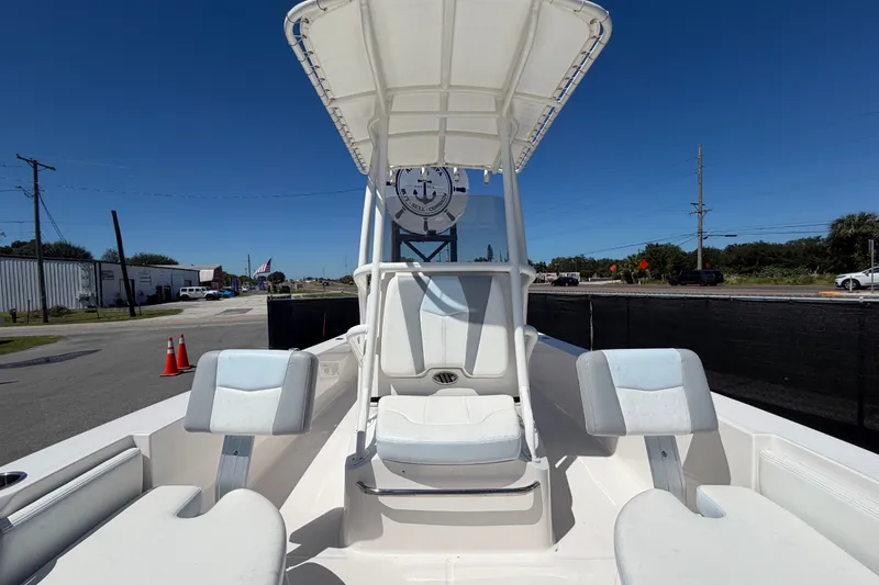 Slide: The Image of 2024 Robalo 206 Cayman boat interior with seating and T-top under clear blue sky. - 27