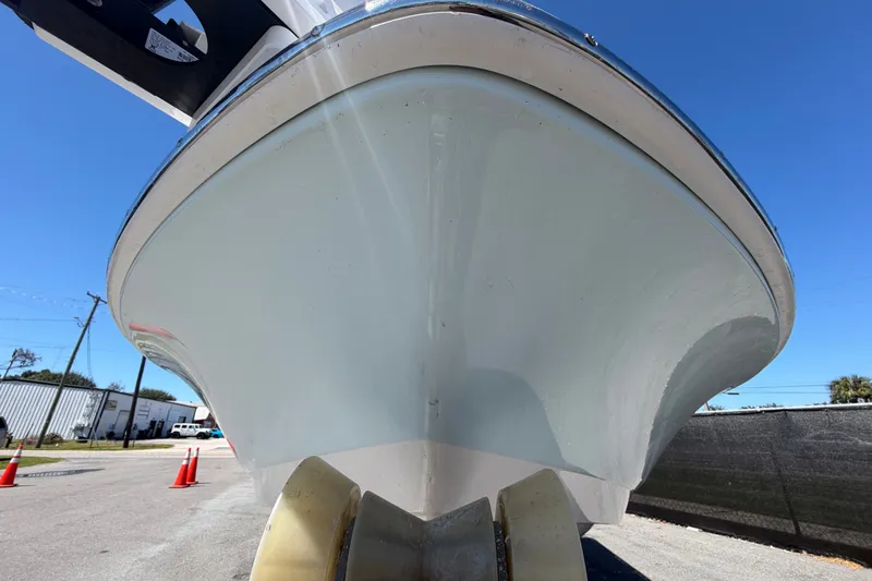 Slide: The Image of 2024 Robalo 206 Cayman boat hull, viewed from below, against clear blue sky. - 9