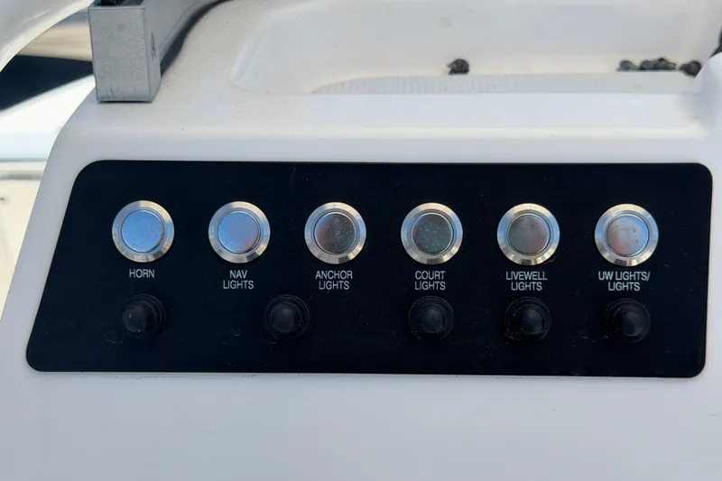 Slide: The Image of Control panel of 2024 Robalo 206 Cayman boat with labeled buttons for lights and horn. - 15