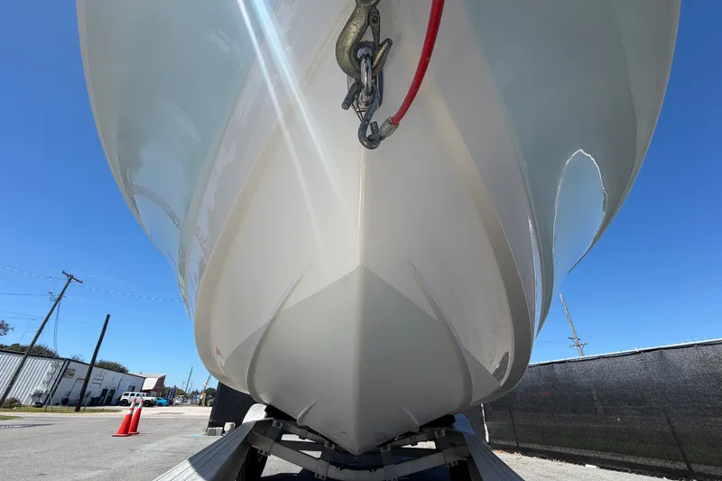 Slide: The Image of 2024 Robalo 206 Cayman boat hull on trailer under clear blue sky. - 10