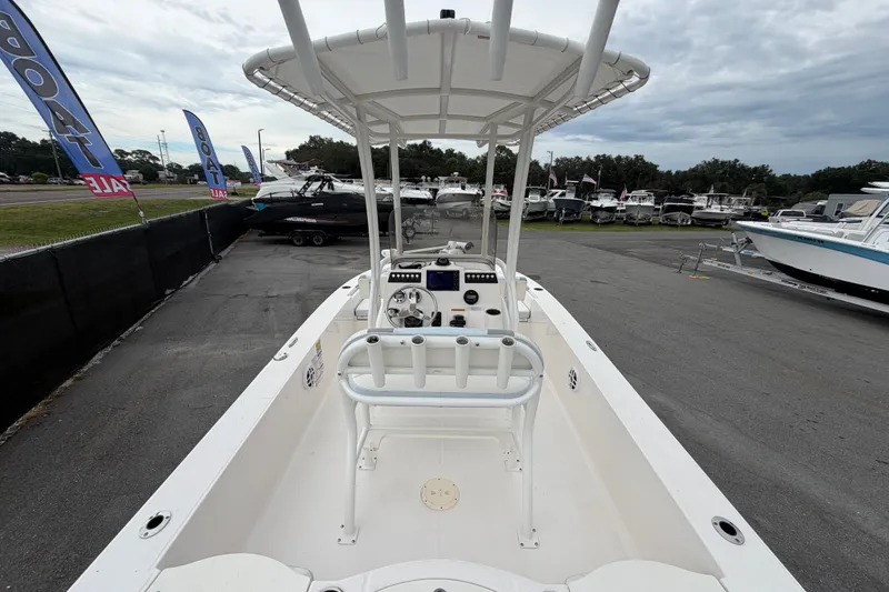 Slide: The Image of 2024 Robalo 206 Cayman boat on display at a dealership with sale banners. - 11