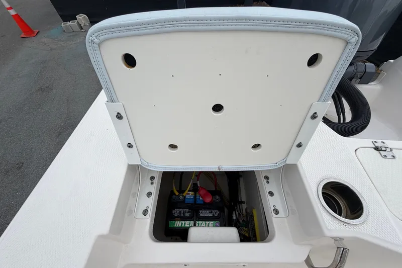 Slide: The Image of An open storage compartment on a boat reveals a battery and cables. - 50