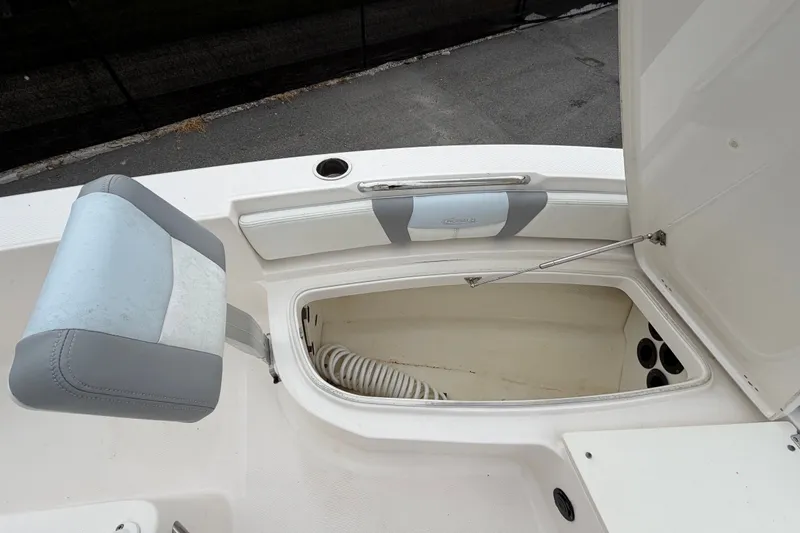 Slide: The Image of 2024 Robalo 206 Cayman boat storage compartment with cushioned seating. - 27