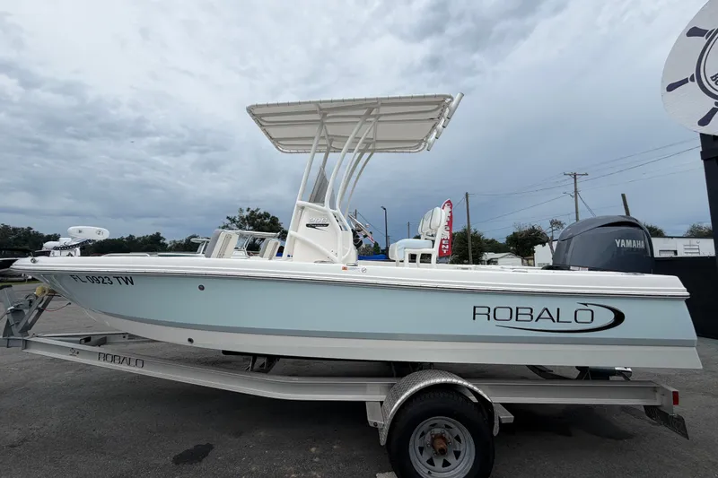 Slide: The Image of 2024 Robalo 206 Cayman boat on trailer, featuring Yamaha engine, under cloudy sky. - 7