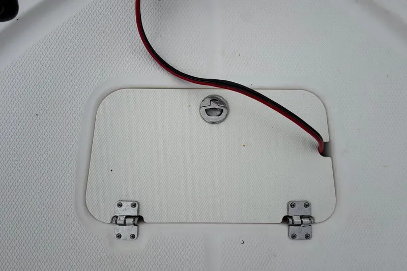 Slide: The Image of A white boat storage hatch with hinges and a red cable. - 33