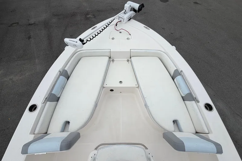 Slide: The Image of The image shows the bow of a 2024 Robalo 206 Cayman with cushioned seating and a trolling motor. - 24