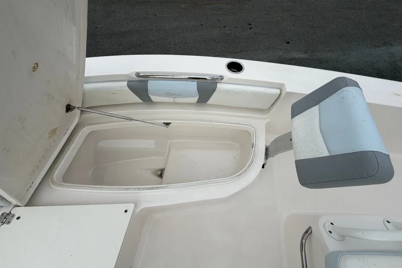 Slide: The Image of The image shows the seating area of a Robalo 206 Cayman boat with storage and cushioning. - 31