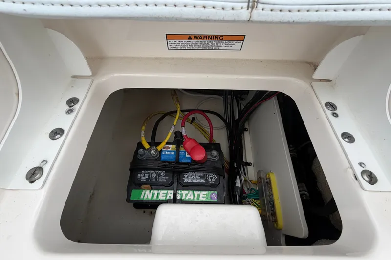 Slide: The Image of Battery compartment of a 2024 Robalo 206 Cayman boat, featuring an Interstate battery. - 51