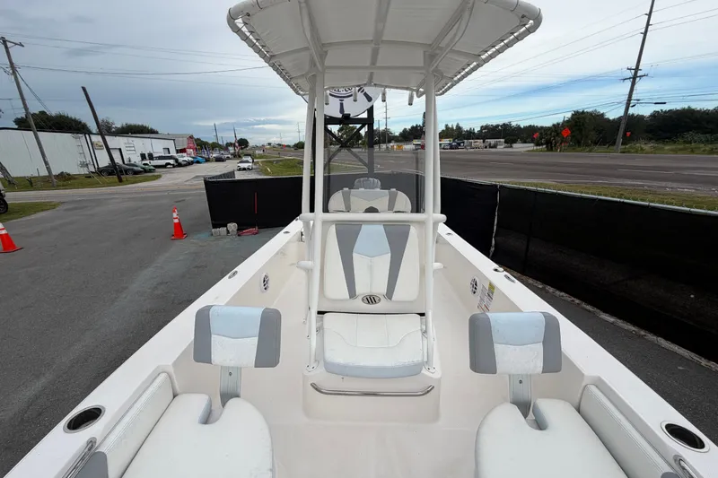 Slide: The Image of 2024 Robalo 206 Cayman boat interior with seating and console, parked near a road. - 39