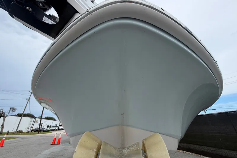 Slide: The Image of 2024 Robalo 206 Cayman boat hull, viewed from below, with overcast sky. - 9