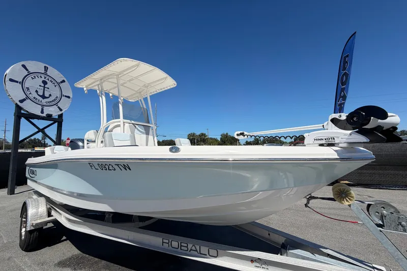 The Image of 2024 Robalo 206 Cayman boat on trailer under clear blue sky. - 0
